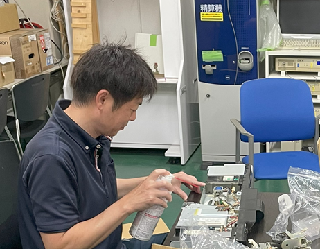 通貨処理機の設置をしている男性作業員